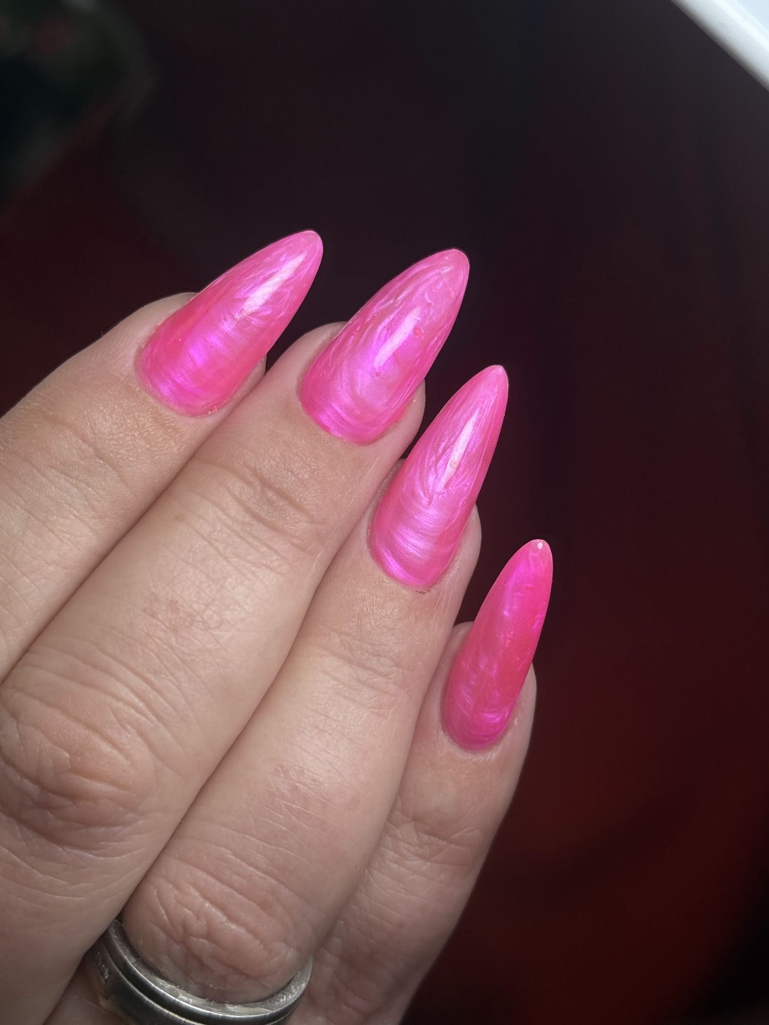 Fuchsia stiletto nagels met een gemarmerde glans